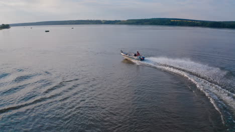 white speed boat floats on river. motor boat with powerful outboard motor fast floating on water