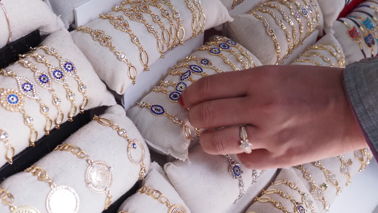 악한 눈의 마법을 가진 금 팔를 가리키는 여자의 손