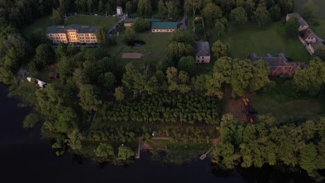 a stunning drone view of katvari village at sunset, highlighting the katvari linden tree by the lake