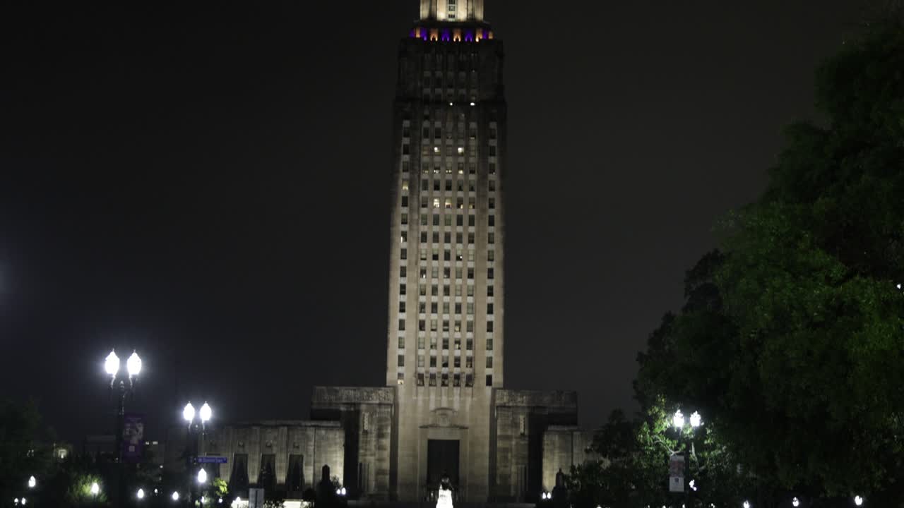 밤에 루이지애나 주 바톤 루즈의 루이지애나 주 의회 건물이 거리로 기울어져 있습니다.