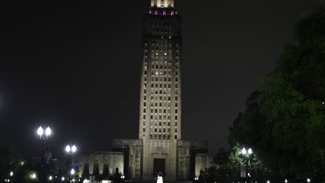 Louisiana-state-capitol-building-in-Baton-Rouge,-Louisiana-at-night-with-video-tilting-down-to-street