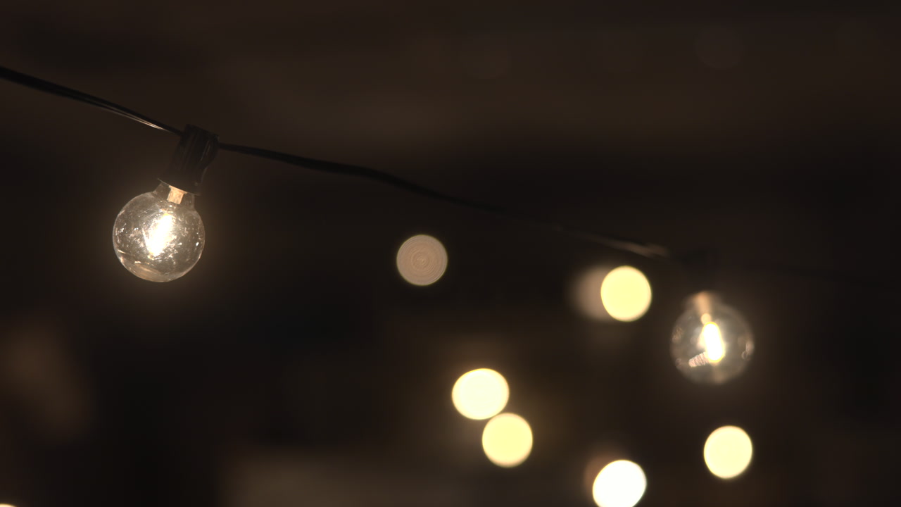 Closeup Warm Globe Bulb String Lights, Soft Bokeh Background, Outdoor Patio Scene, Cafe Illumination, Romantic . Media