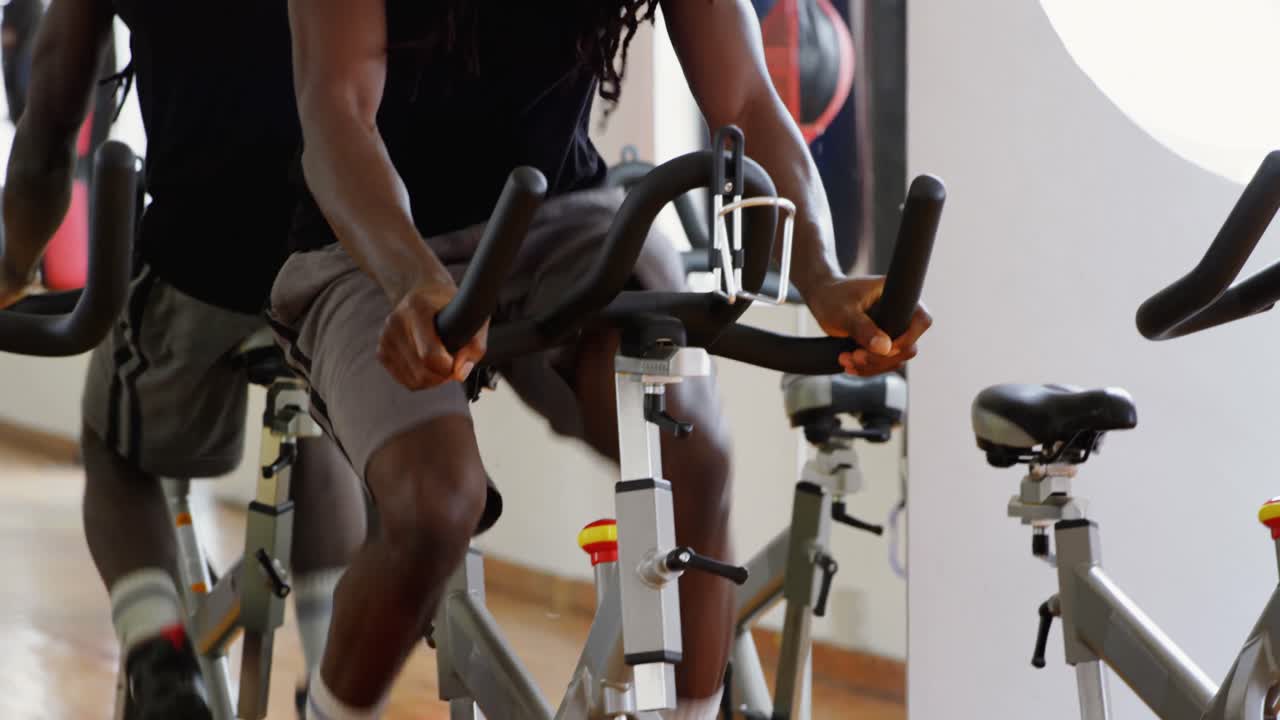 남자 권투 선수 가 운동 자전거 4k 를 타고 운동 하고 있다