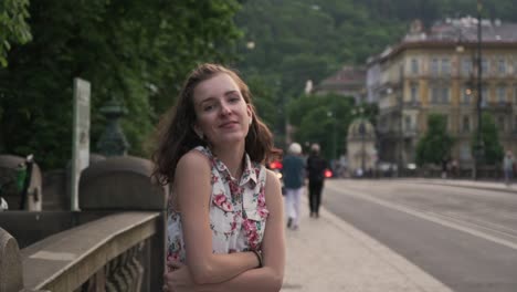 mujer caminando en la ciudad de praga, girando hacia la cámara en cámara lenta, cara sonriente vista de cerca