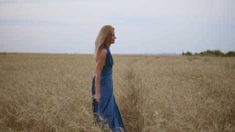 beautiful young happy girl running through wheat field. freedom concept. turning around and looking to the camera. slow motion