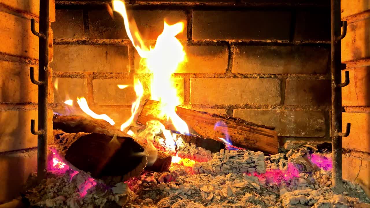 Primer plano en cámara lenta de leña ardiendo en una parrilla exterior.