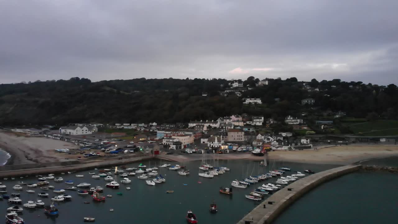 Aerial panning left shot of the Cobb at Lyme Regis Dorset England on a cloudy morning at sunrise