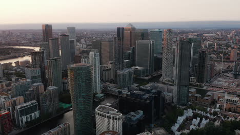 Aerial-panoramic-view-of-tall-modern-office-buildings-in-futuristic-Canary-Wharf-borough-in-sunset-time.-London,-UK