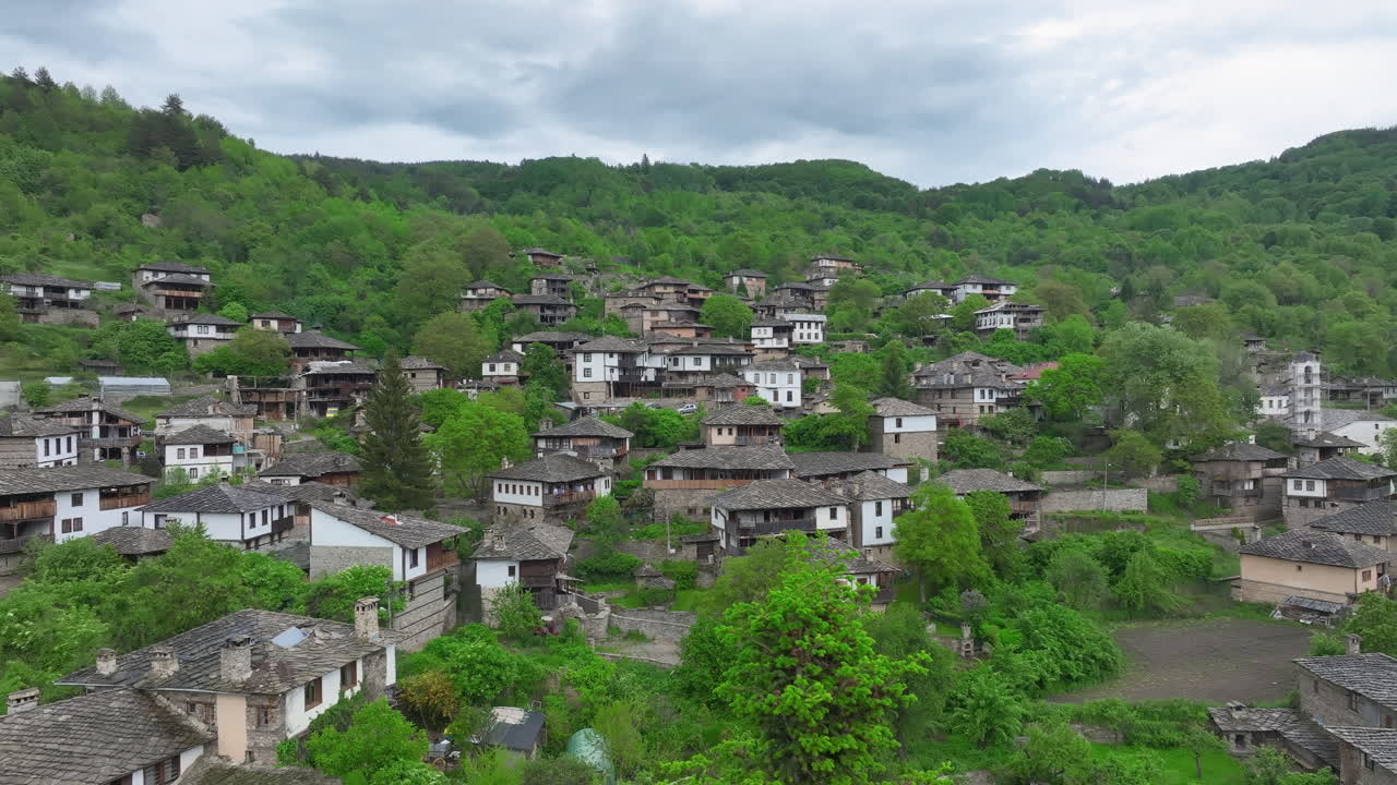 Traditional Stone Village Of Kovachevitsa In Bulgaria With Slate-roofed Houses In Lush Green Hills. aerial panning shot