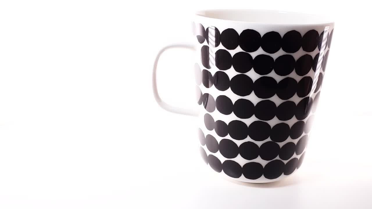 tiro deslizante de una taza de café aislada con patrón marimekko sobre fondo blanco, diseño elegante de finlandia
