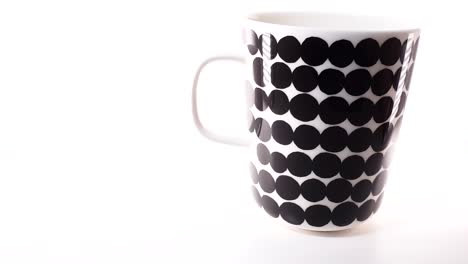 Tiro-Deslizante-De-Una-Taza-De-Café-Aislada-Con-Patrón-Marimekko-Sobre-Fondo-Blanco,-Diseño-Elegante-De-Finlandia