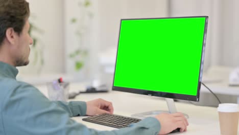 hombre usando el escritorio con pantalla clave de croma verde