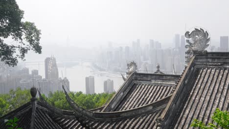 Old-styled-Chinese-house-roof-with-ornate-structures-overlook-Chongqing-City-haze-filled-skyline