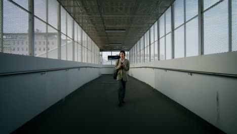 woman walking through a train station bridge