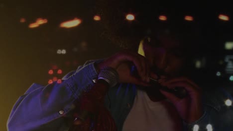 Animation-of-road-at-night-over-african-american-man-playing-harmonica-on-stage