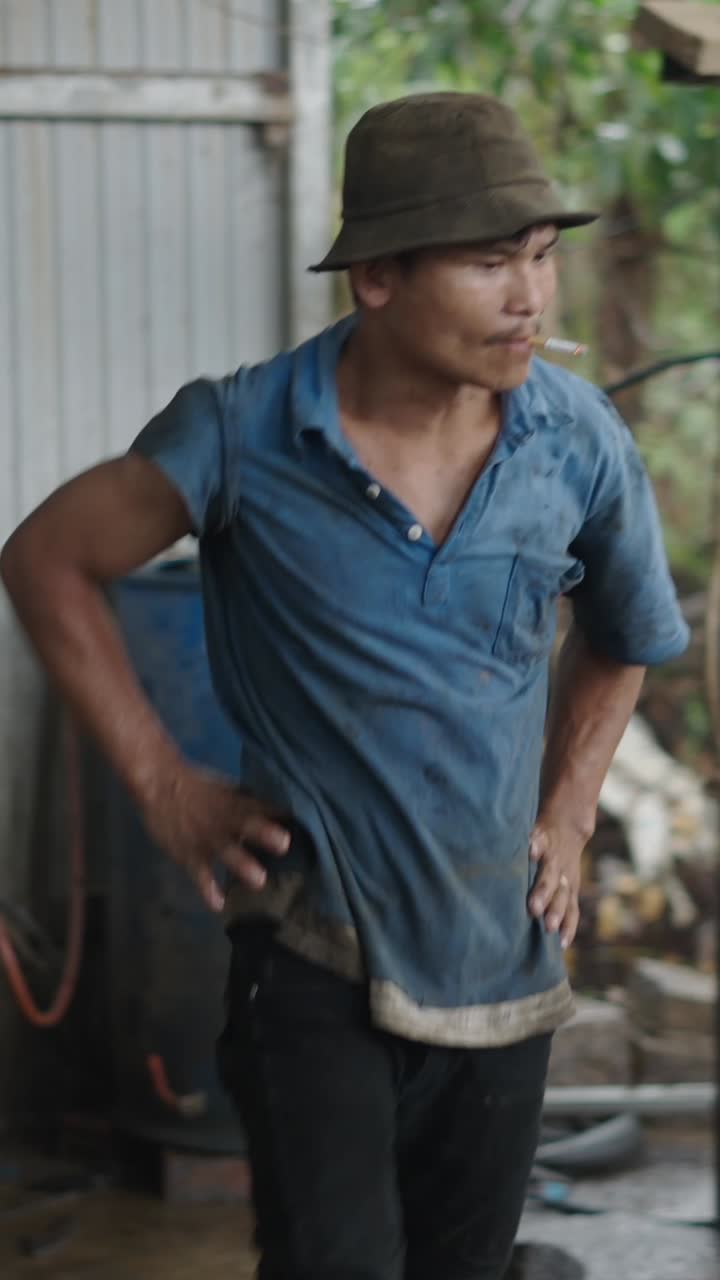 Man in hat smoking cigarette outdoors