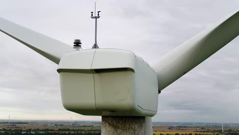 wind turbine nacelle from behind using an aerial drone for inspection, close up shot panning around