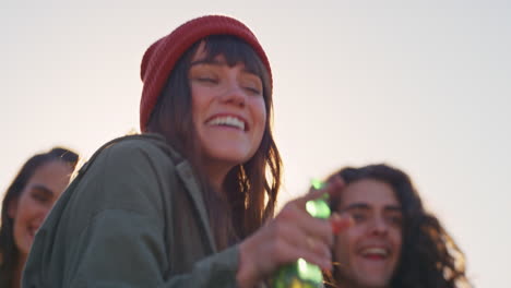 mujer caucásica bailando grupo de amigos diversos pasando el rato disfrutando de la fiesta en la azotea bailando música al atardecer bebiendo alcohol divirtiéndose en la reunión de fin de semana