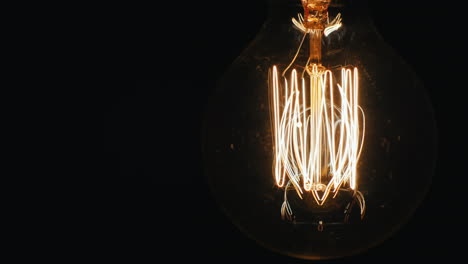 Slowly-Lit-Electric-Bulb-Using-A-Dimmer-On-A-Black-Background