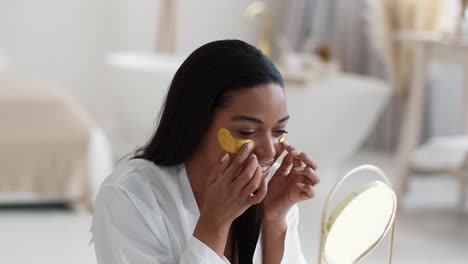 woman applying gold eye masks
