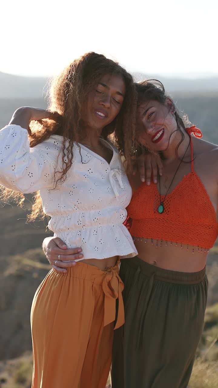 Dos mujeres felices abrazándose al aire libre a la hora dorada