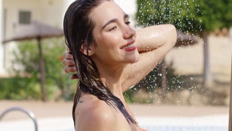 belleza sonríe a la cámara mientras está de pie en la ducha