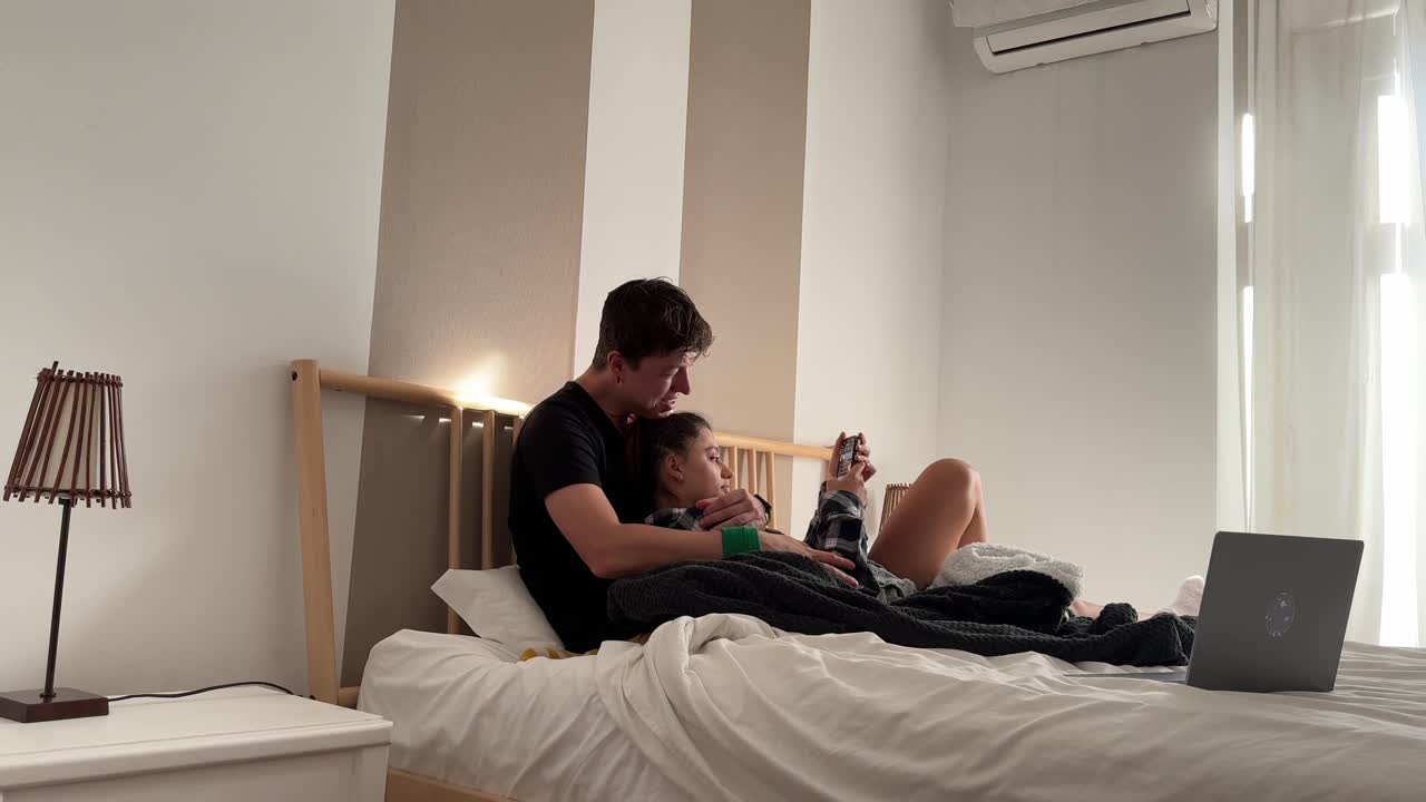 una pareja relajándose en el dormitorio.