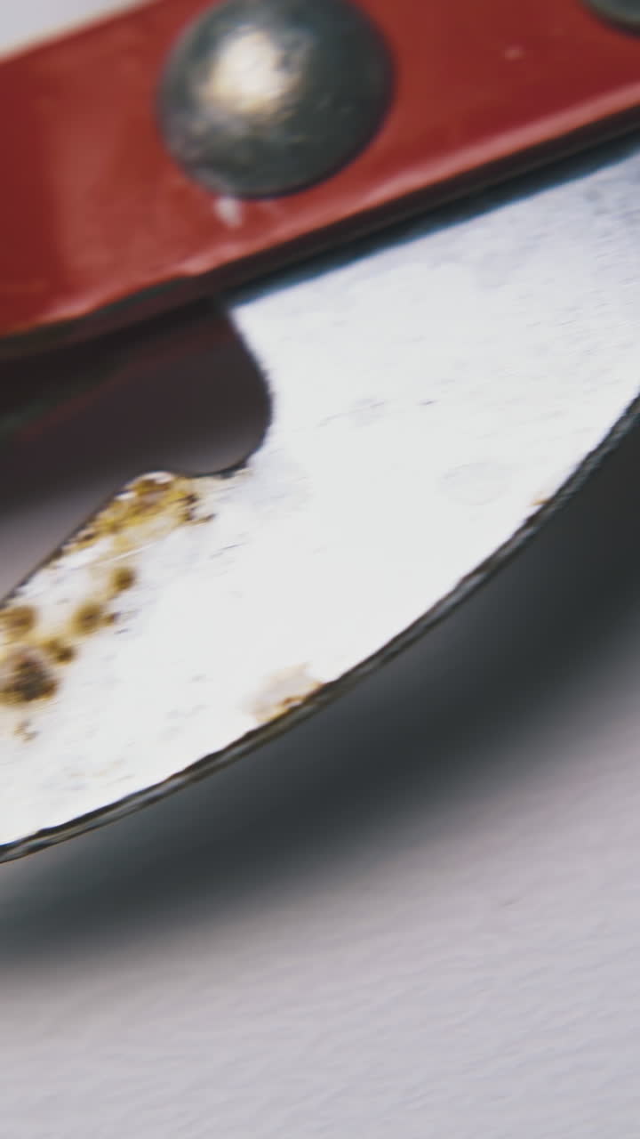 vintage sharp metal can opener with red handle lies on clean white background extreme close view