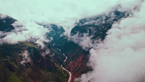 El-Vuelo-Aéreo-De-Un-Dron-Hacia-Atrás-Revela-La-Inmensidad-Del-Cañón-Del-Colca,-Las-Nubes-Posteriores-A-La-Lluvia,-La-Exuberante-Vegetación-Y-El-Río-Colca