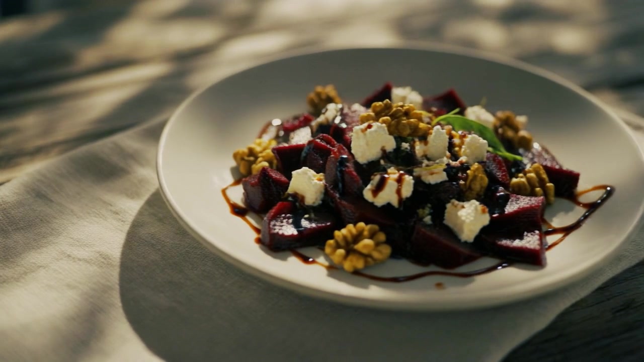 Frischer Rote-Bete-Salat mit Feta-Käse und Walnüssen auf einem Holztisch.