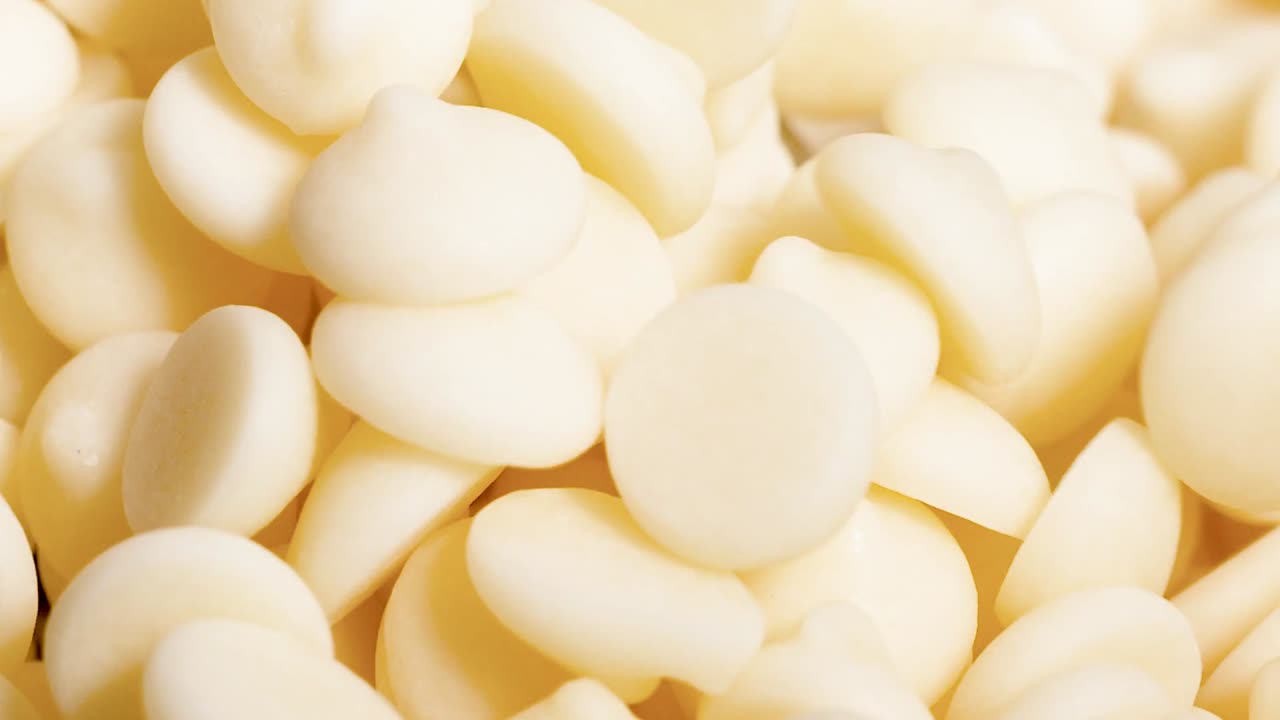 Detailed view of a dense cluster of white chocolate chips, showcasing their smooth texture.