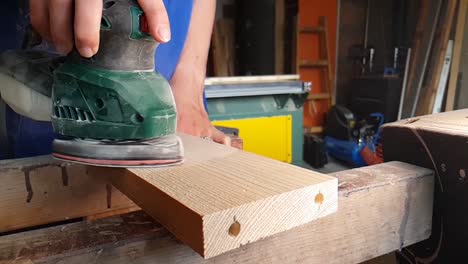 Slowmotion-of-woman-grinding-wooden-board-with-vibrating-grinding-machine