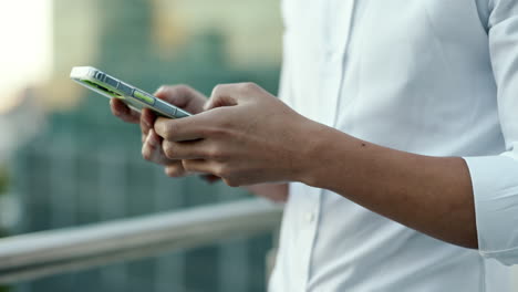 Phone,-buildings-and-hands-of-businessman-typing