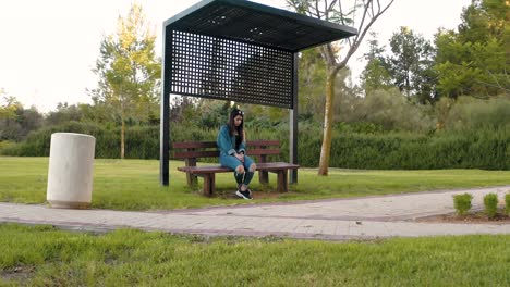 la chica se sienta en un banco en el parque