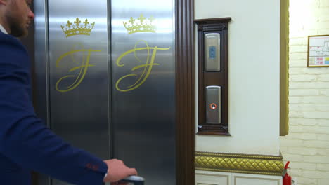 man pushing button of elevator. young man waiting for elevator at hotel