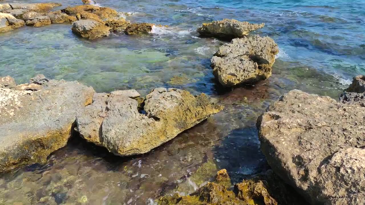 Onde delicate che si infrangono su una costa rocciosa.