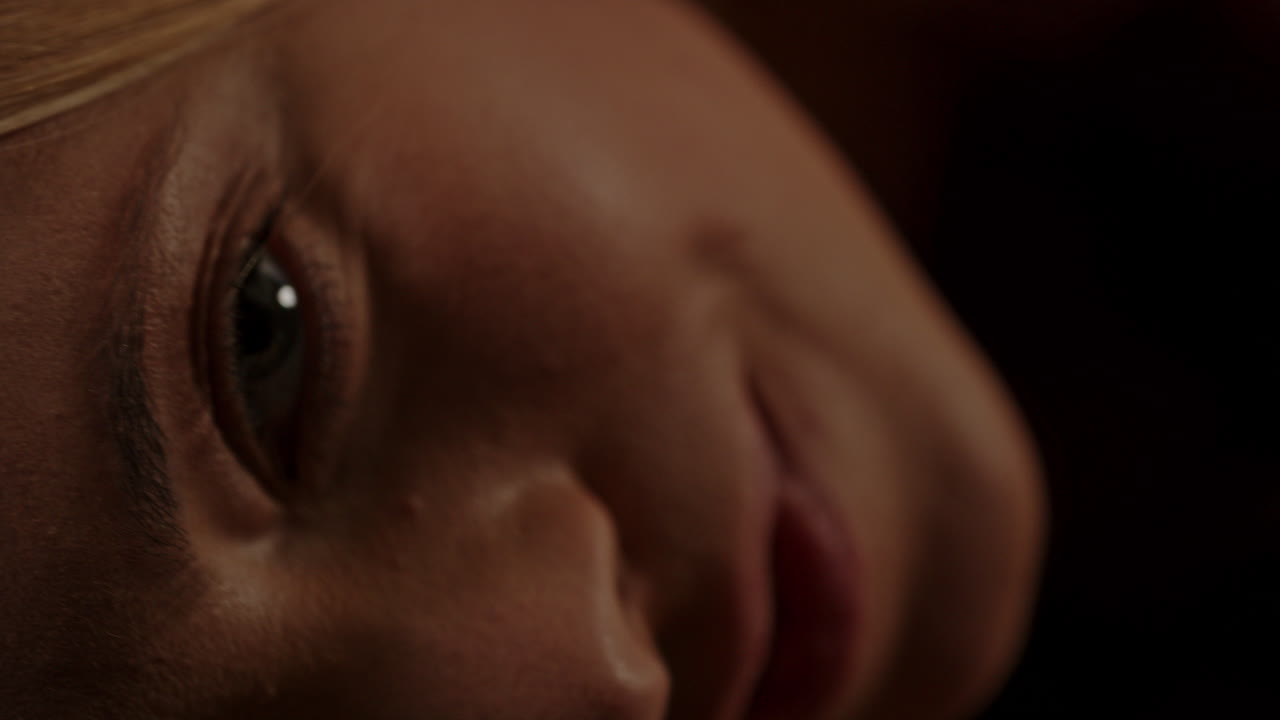 Beautiful macro of an attractive woman looking at the camera and rolling around in slow motion