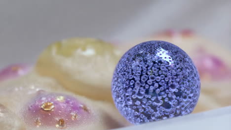 close-up of a purple glass sphere on decorative background