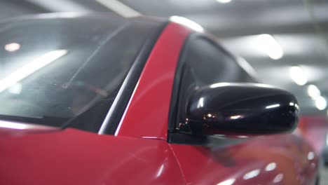 man getting into red sport car on drivers side. closeup view