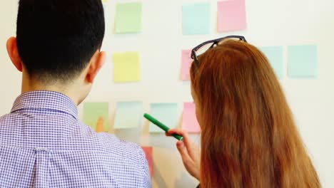 ejecutivos de negocios discutiendo sobre notas adhesivas