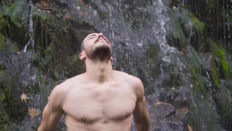 hombre musculoso y cascada en cámara lenta.