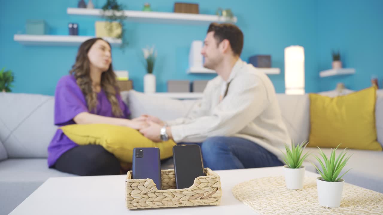una joven pareja feliz pasando tiempo sola en casa, sin prestar atención a sus teléfonos.