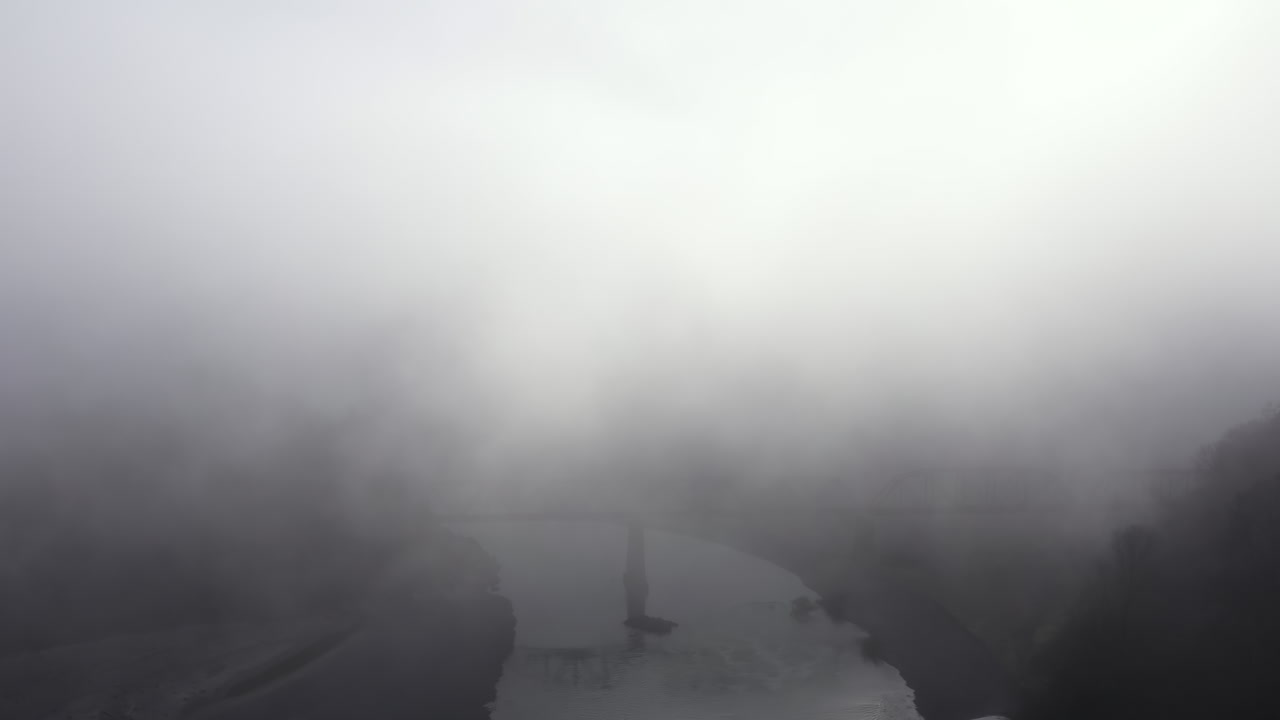 Train Trestle bridge shrouded in fog, aerial view