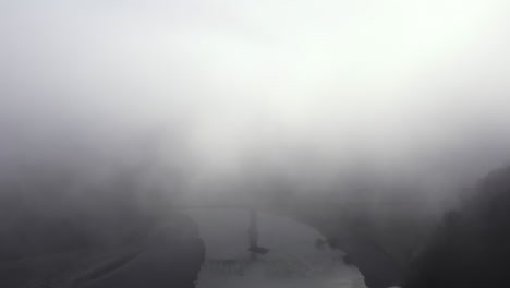 train trestle bridge shrouded in fog, aerial view