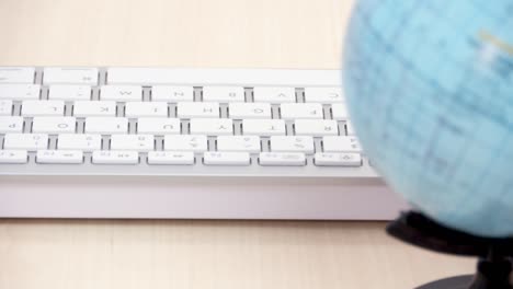 globe in front of white computer keyboard