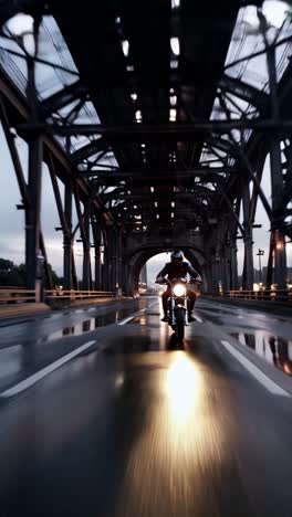 motorcycle rider on a wet bridge at night