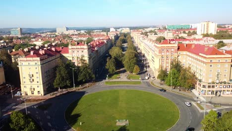 Vehicles-Driving-On-Roundabout-With-View-Of-Buildings-In-Socialist-Realism-Architecture