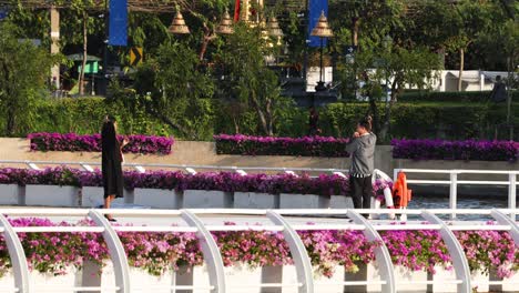 two people walking over a bridge with flowers