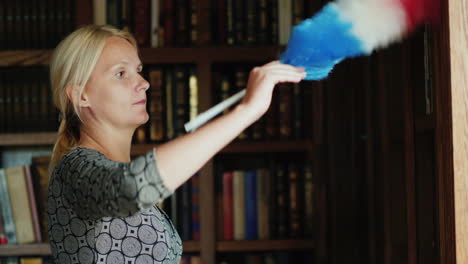 woman dusting bookshelves