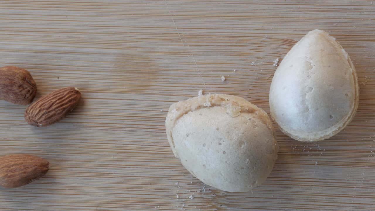 Panning view of almonds, spanish biscuits and butter on a table.